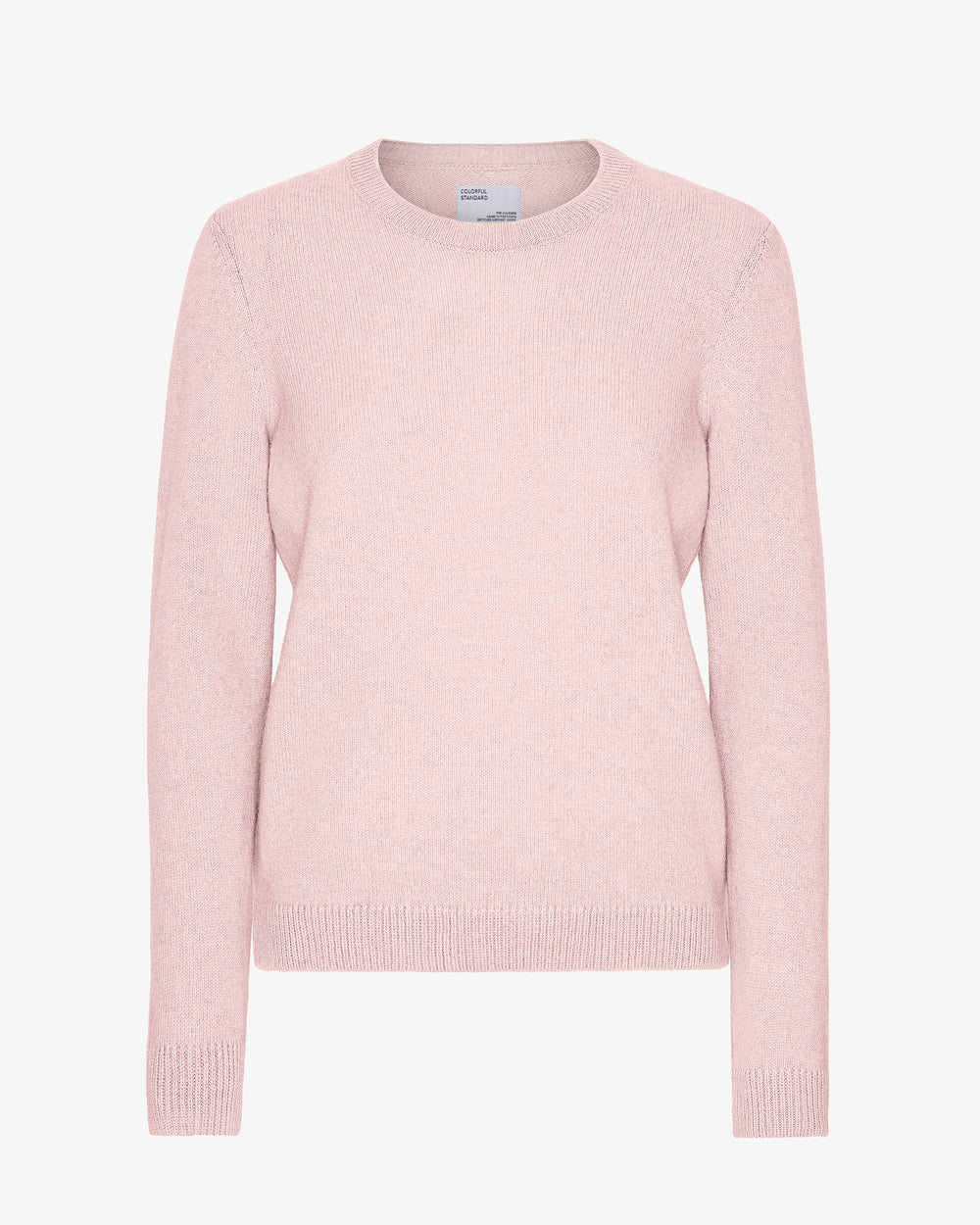The Classic Merino Wool Crew - Faded Pink by Colorful Standard is a light pink crewneck knit sweater with long sleeves and a classic silhouette, crafted from recycled merino wool and shown against a white background.