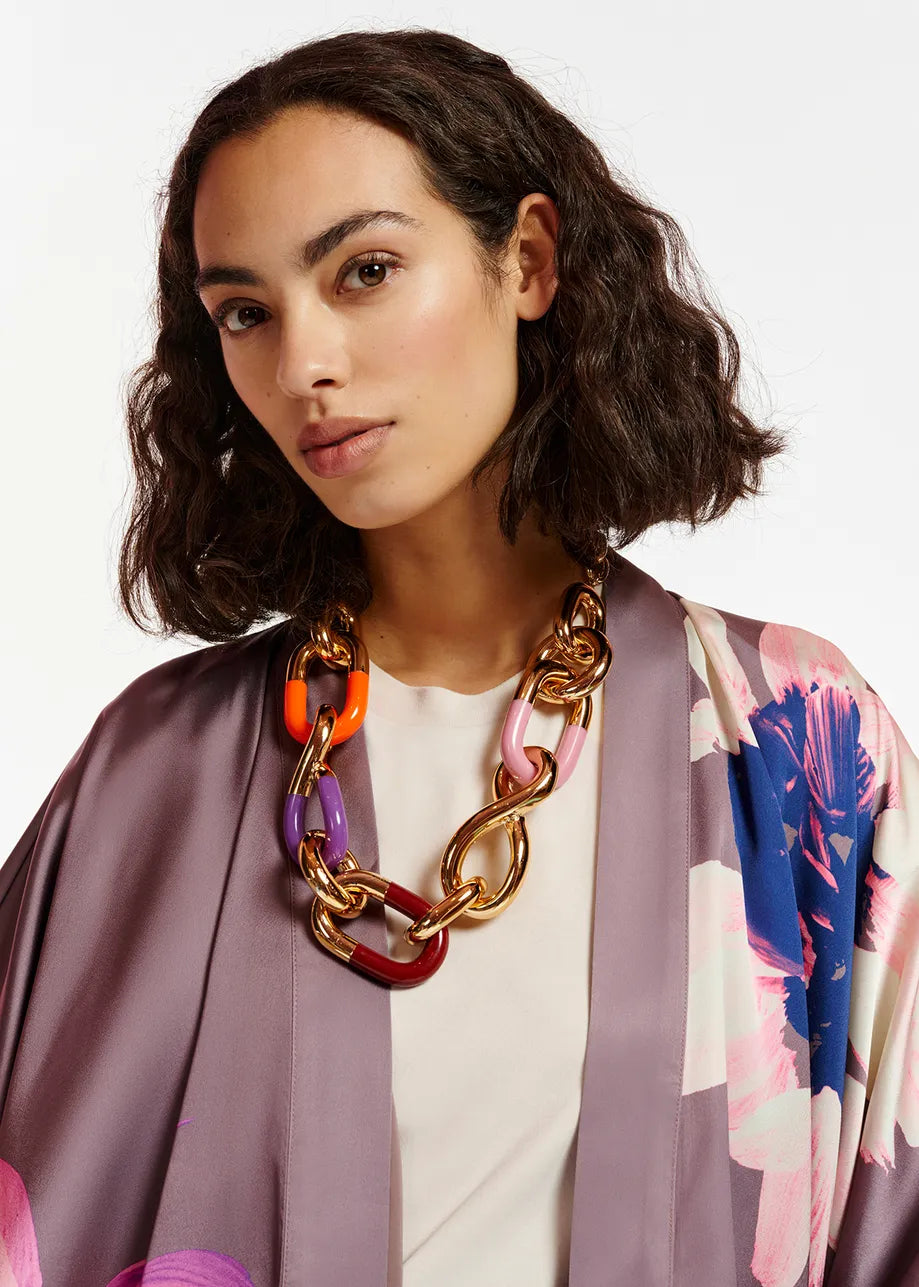 The model is wearing a floral printed robe with an Essentiel Antwerp Ean - Gold, orange and purple chunky chain necklace.