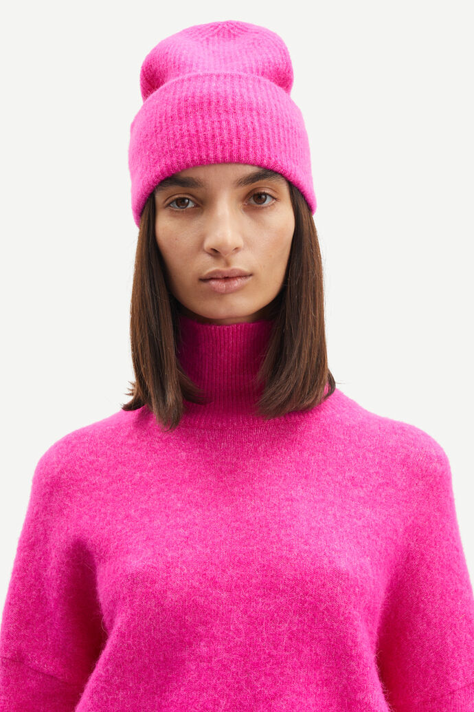 A model wearing a pink merino wool sweater and Samsøe Samsøe Nor Hat.