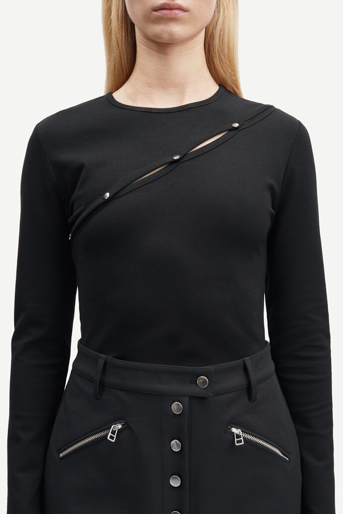 The model is wearing the Luanne Blouse - Black, a slim-fitting black long-sleeved top with zippers, made of LENZING ECOVERO Viscose by Samsøe Samsøe.