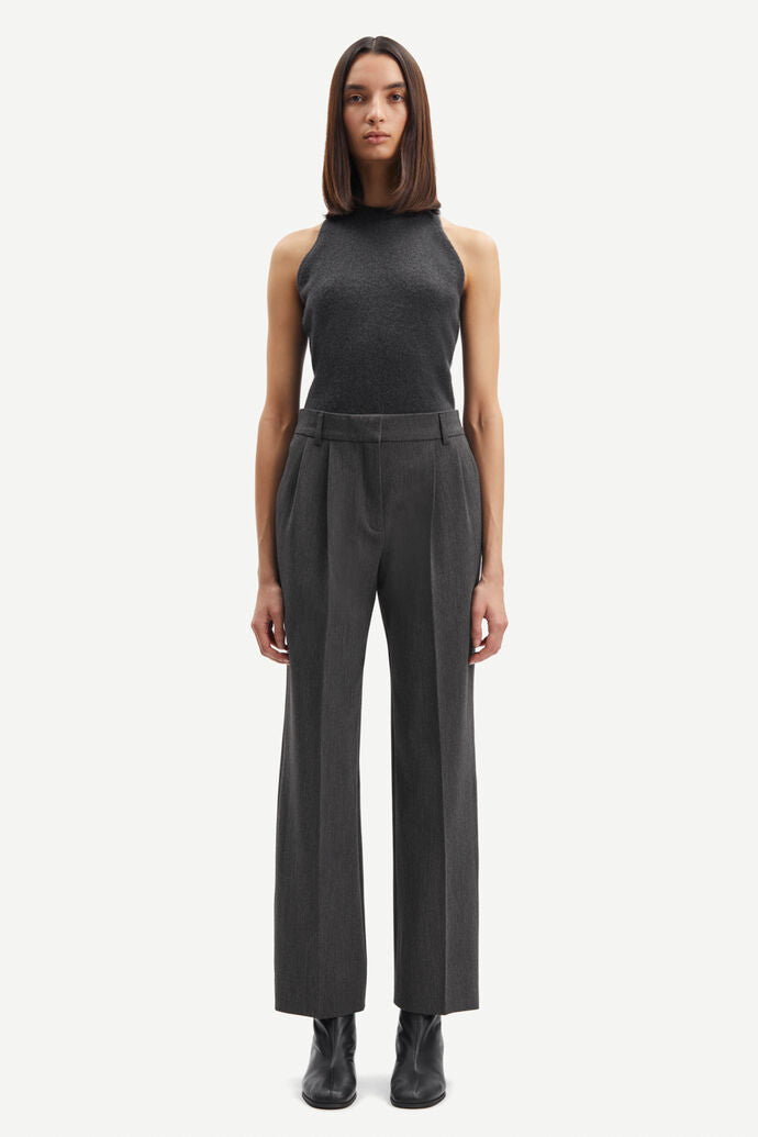 The woman is wearing a black tank top and Haveny Trousers - Dark Grey Melange made from recycled polyester pants by Samsøe Samsøe.