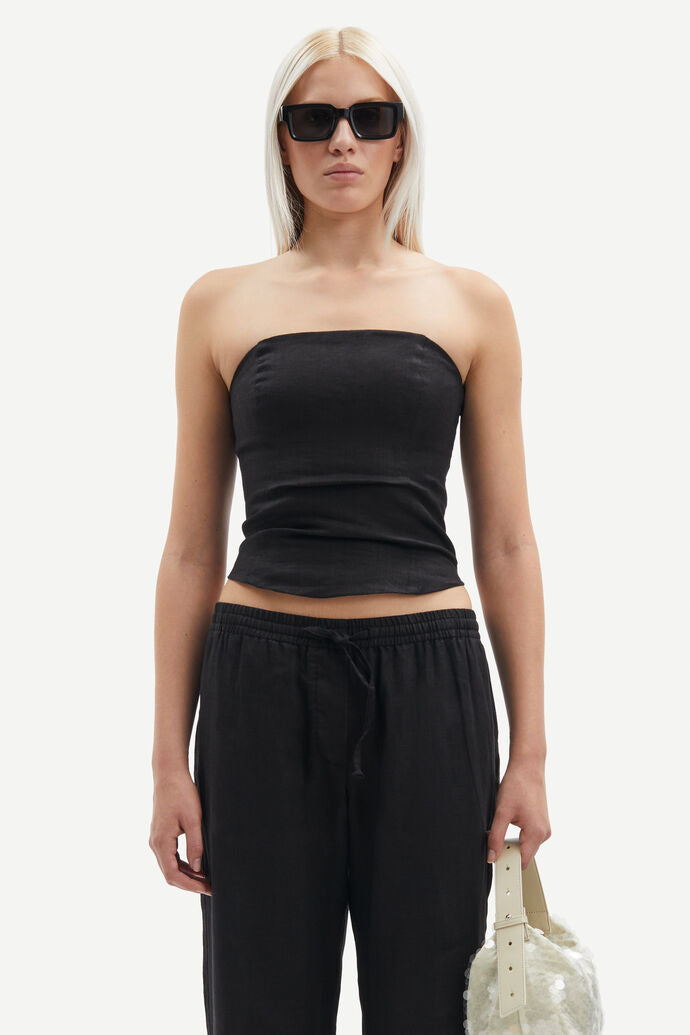 Model wears black bandeau style top in linen