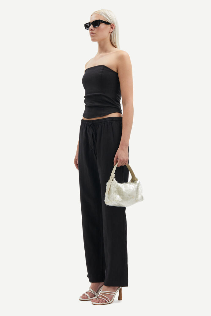 Model wears black bandeau style top in linen - side