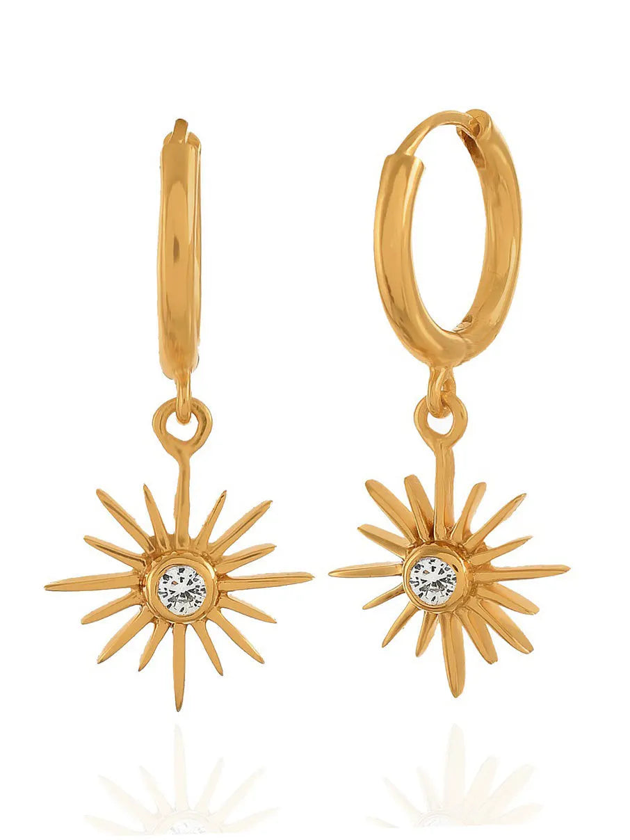 A pair of everyday gold sunburst earrings with diamonds, perfect for adding a layered touch of Shyla - Felicity Huggie Clear - Gold elegance to any outfit.