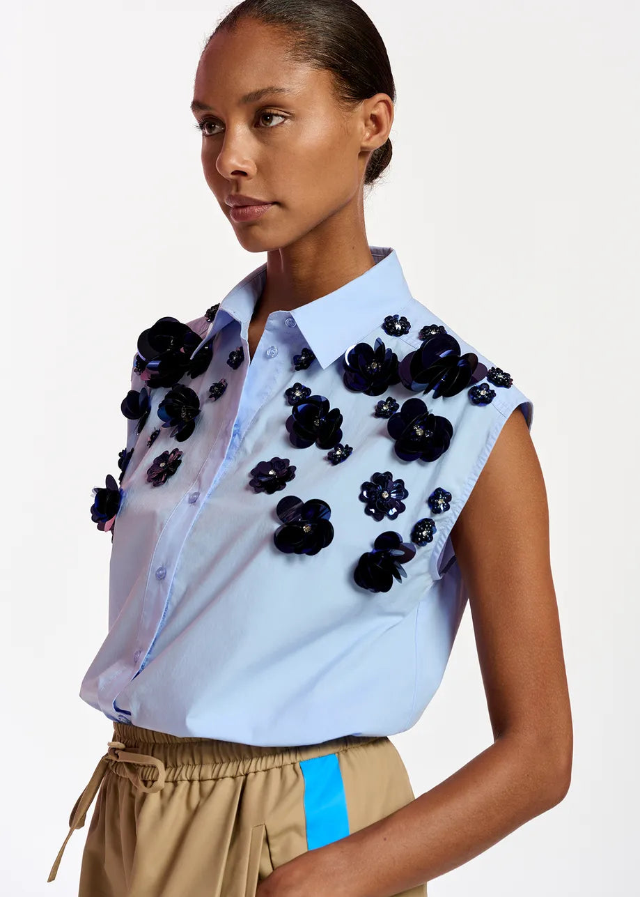light blue sleeveless shirt with dark blue sequin flower embellishments
