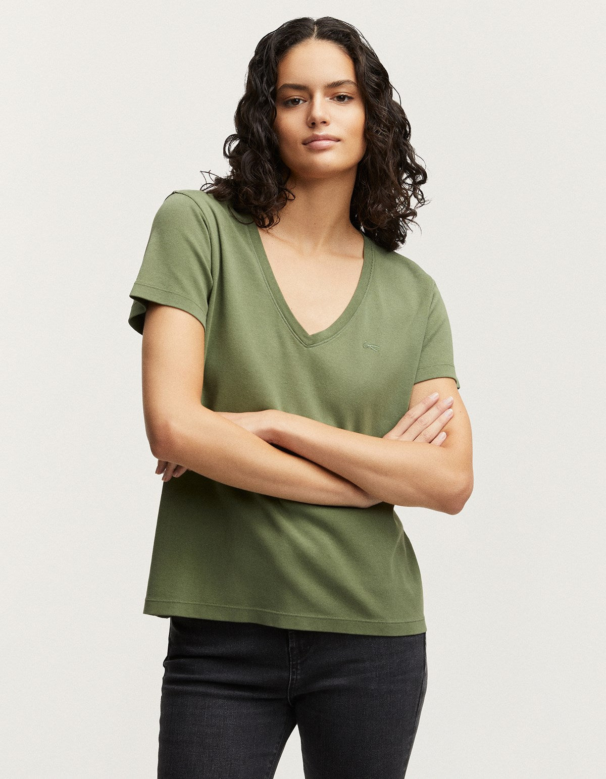 Ramona, a women, wears a green Denham RAMONA Tee Rib Cotton Jersey v-neck t-shirt.