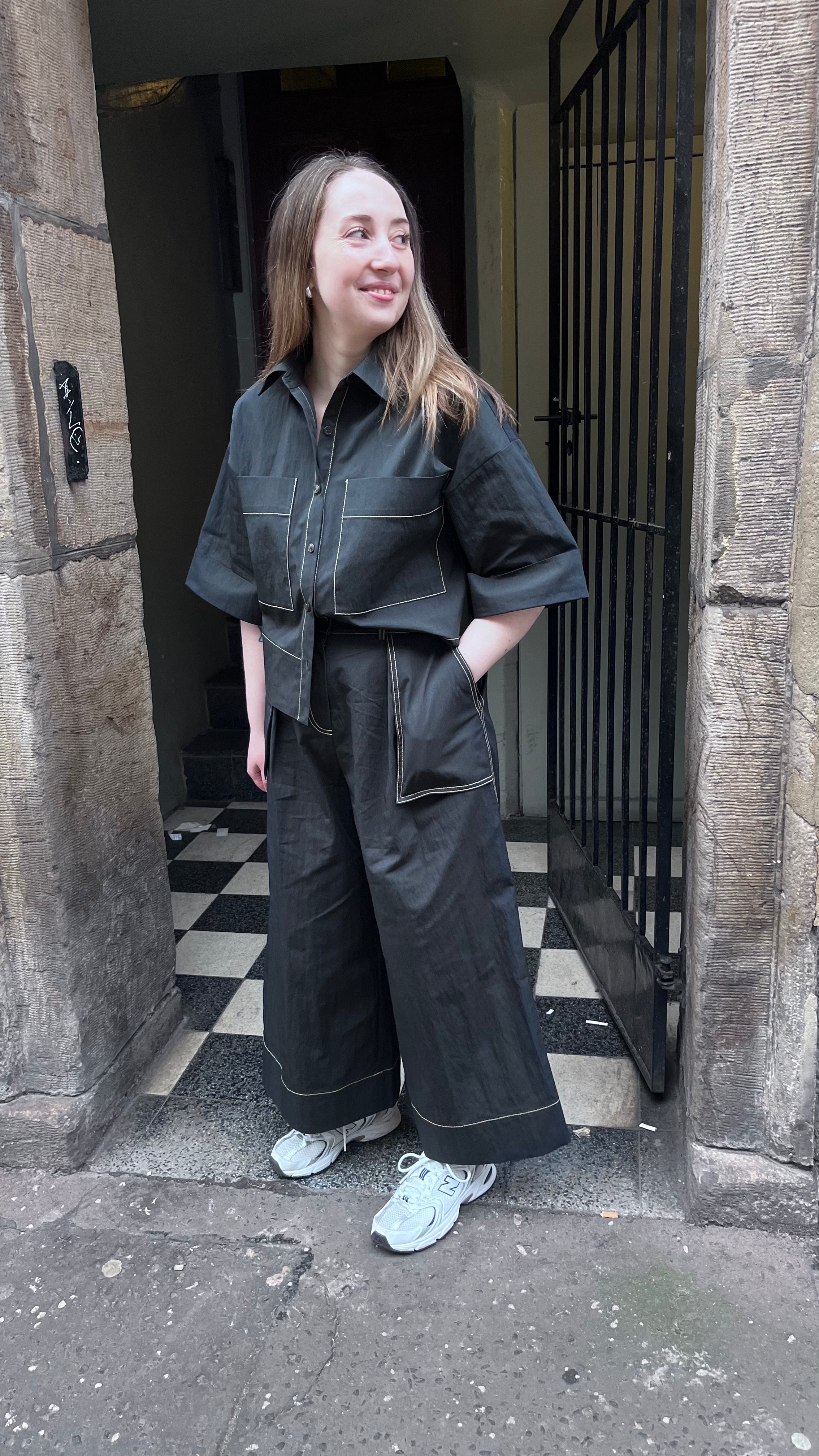 Emin and Paul black wide leg contrast stitch trousers worn by female in street