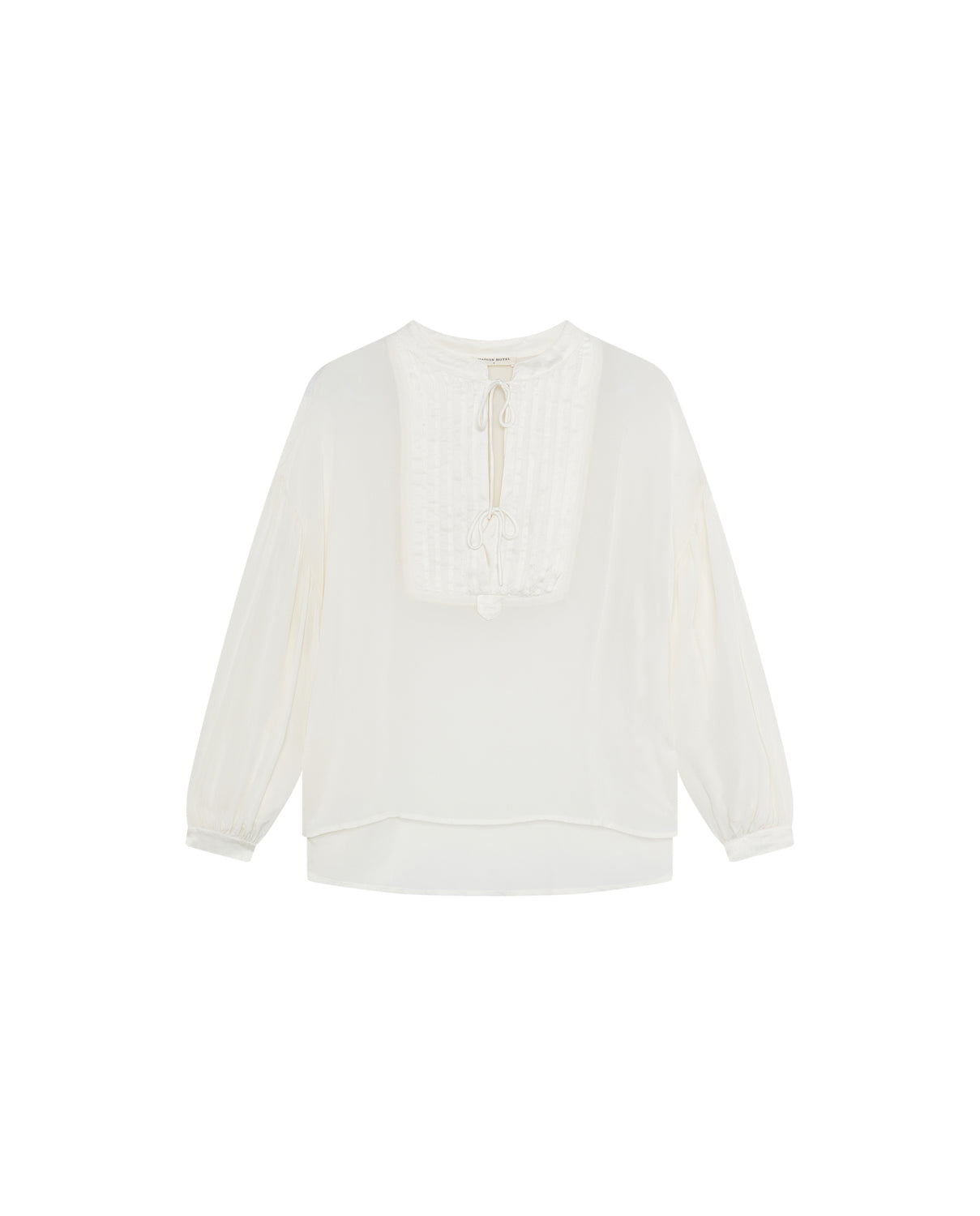 The Giovanni Blouse - Ivory by Maison Hotel is a vintage-inspired piece made from lightweight fabric, featuring long sleeves, a round neckline, pintuck panel, front tie detail, and a relaxed fit.
