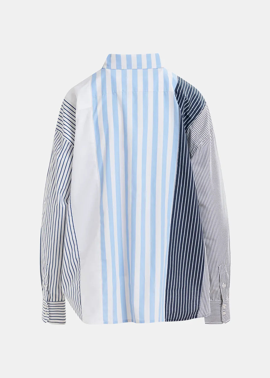 The Essentiel Antwerp Hemix Striped Shirt in a cotton blend features an oversized silhouette with multi-patterned blue, navy, and white vertical stripes. The back showcases varying stripe widths on each section for an elegant appearance.