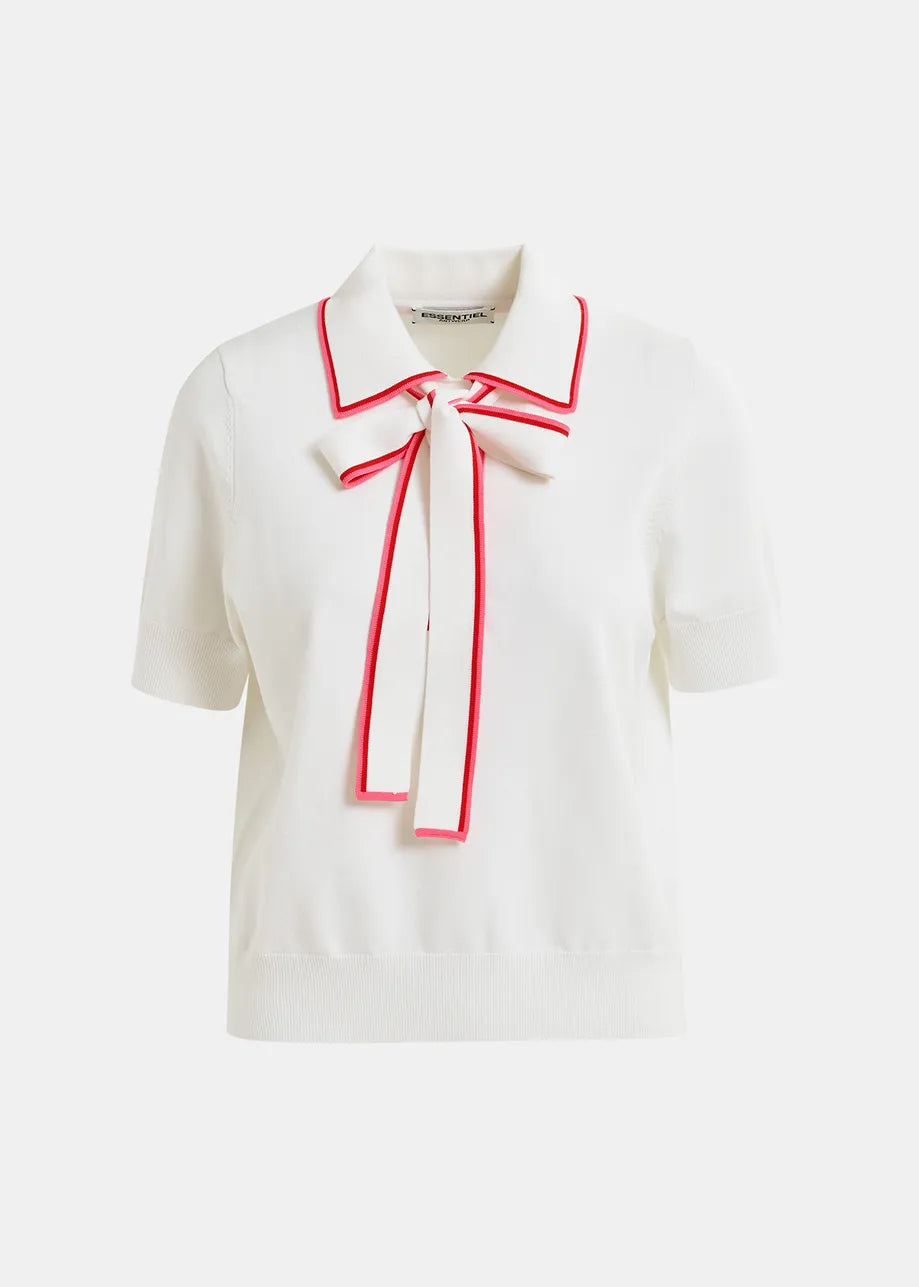 The Hight Knitted Polo by Essentiel Antwerp features a white short-sleeve design with a large bow tie on the front, accented by chic red trim on the collar and bow edges for an effortlessly chic look.