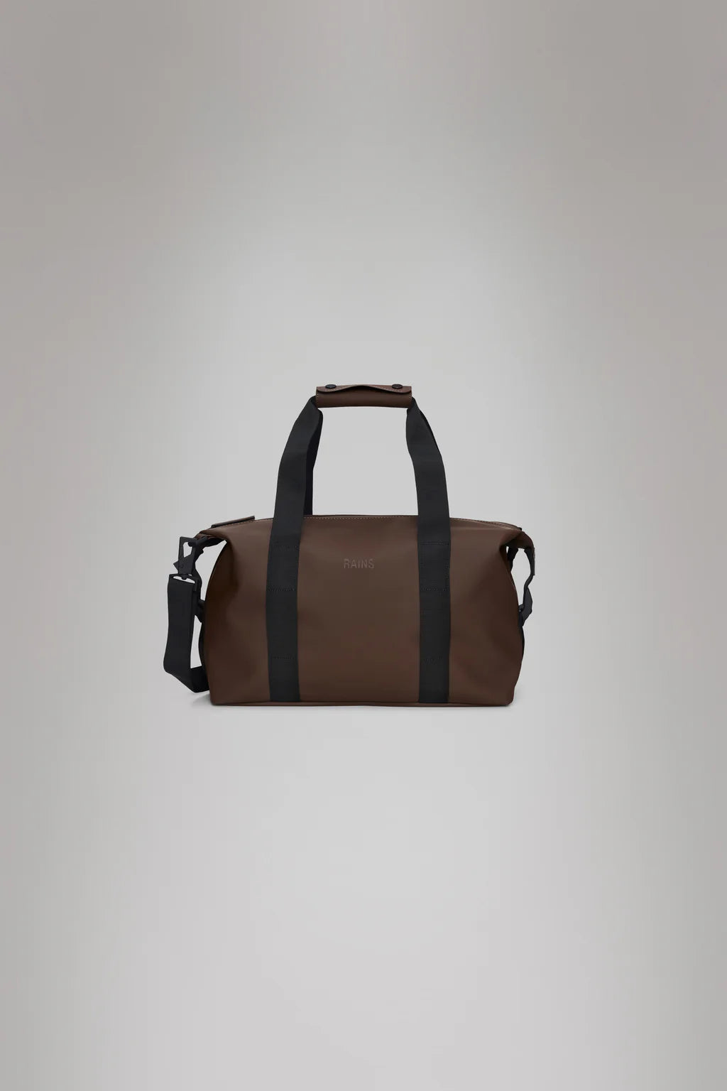 The Hilo Weekend Bag Small - Frame by Rains, featuring a brown design with black straps and a shoulder strap, crafted from the brand's signature fabric, is displayed against a gray background.