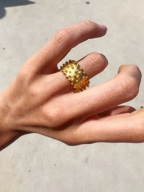 A woman's hand with a Shyla - Ilina Ring - Gold