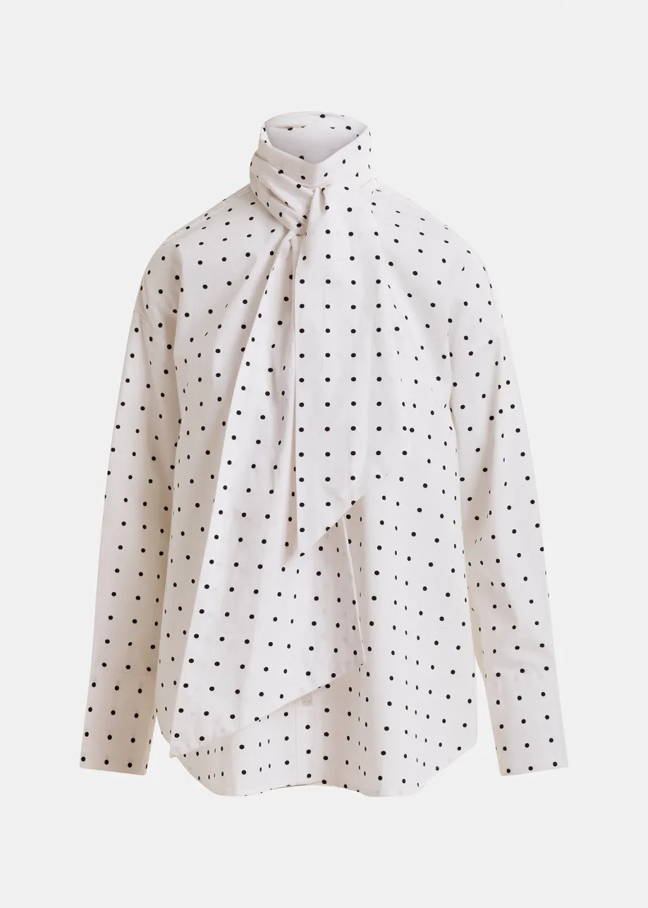 The Imoverit Polkadot Shirt by Essentiel Antwerp features white cotton poplin with black polka dots, a high neck, and an attached draped scarf for a modern twist on the classic tie collar shirt.