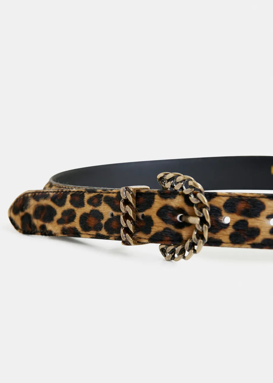 The Ipony Belt - Leopard by Essentiel Antwerp is a cow leather belt with a leopard print, featuring a sculptural metal buckle and gold chain detail, shown against a plain background.