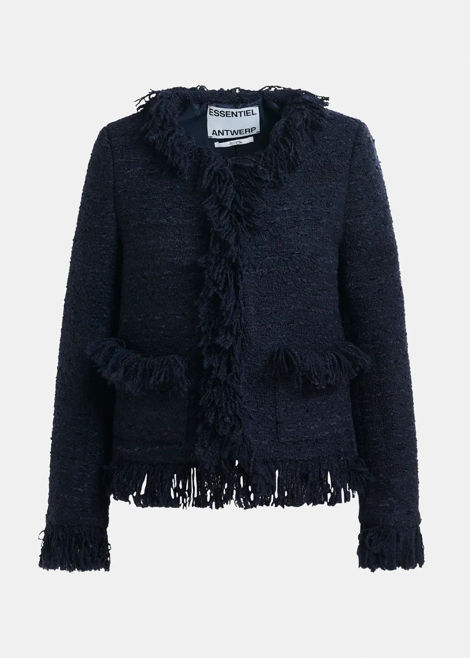 The Iskra Bouclé Jacket by Essentiel Antwerp is a navy wool-blend piece with fringe details on the collar, pockets, sleeves, and hem. It features a boxy silhouette for a modern look.