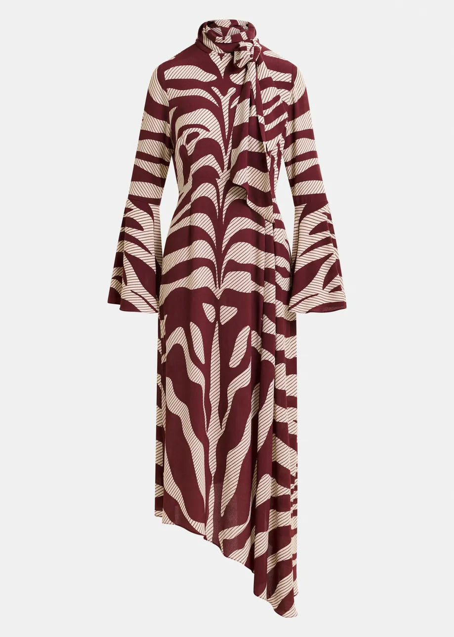 The Istripe Dress - Burgundy by Essentiel Antwerp features long sleeves, a high neck with attached pussy-bow tie, maroon and white abstract print, asymmetrical hem, and flared cuffs.