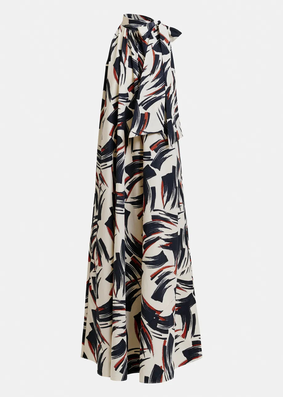 Essentiel Antwerp’s Jayda High Neck Maxi Dress in Burned Red is a long, loose recycled-polyester maxi dress featuring a side view, knotted neckline, and abstract black and red brushstroke pattern on cream.