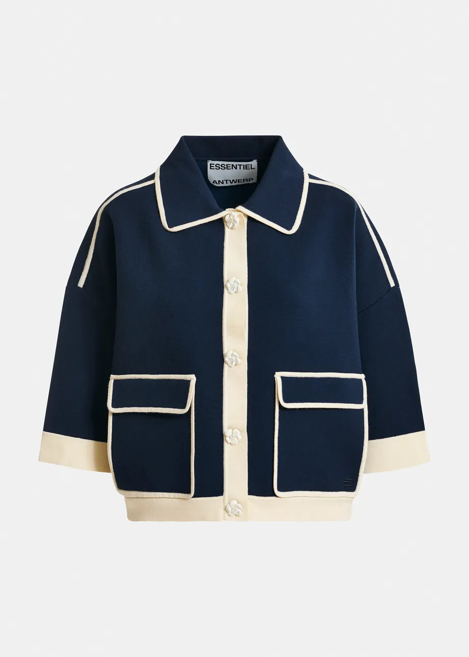 The Jugly Contrast Knit Cardigan by Essentiel Antwerp features a navy design with cream trim, collar, flower snap buttons, and two large front pockets.