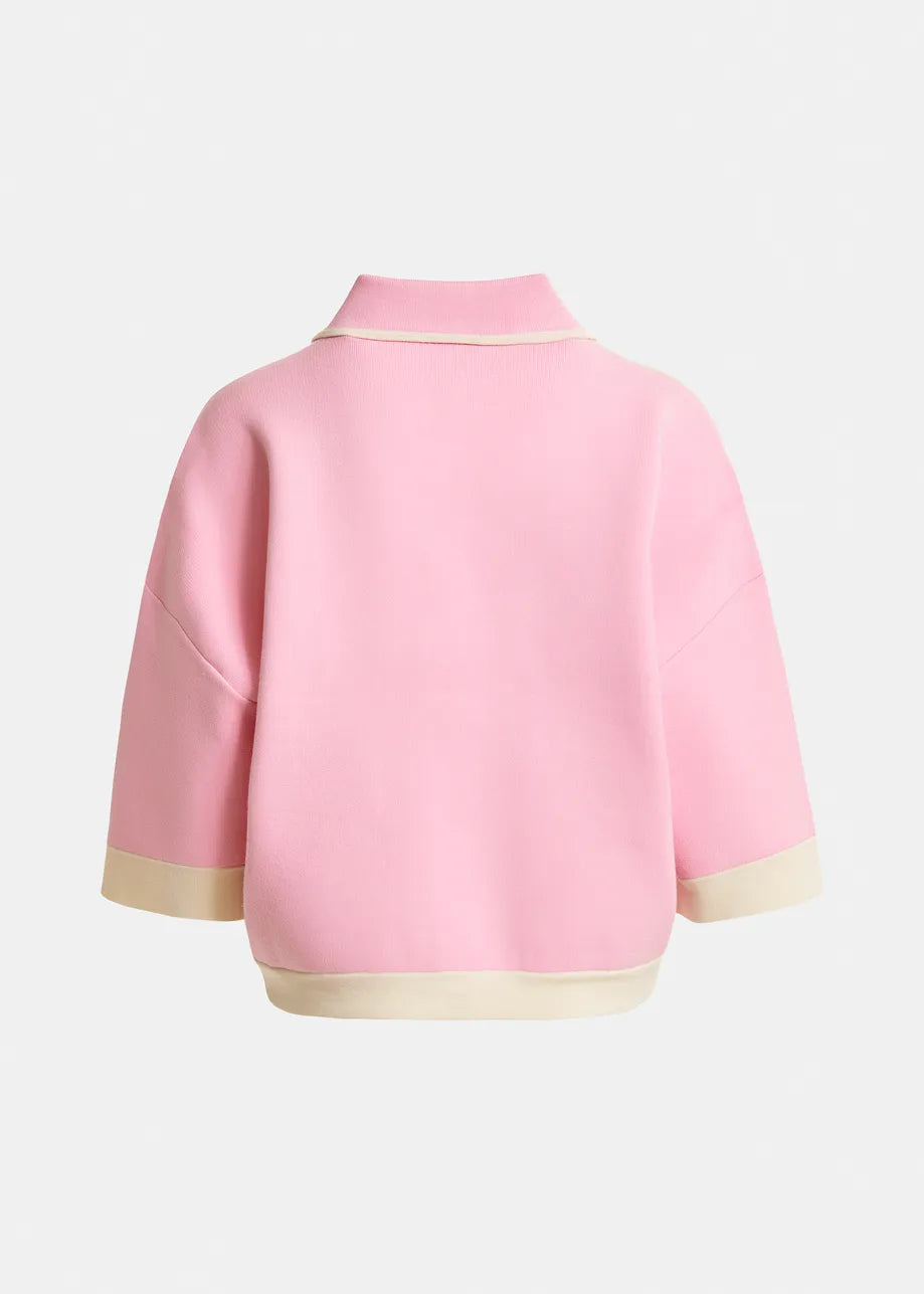 Back view of the Essentiel Antwerp Jugly Contrast Knit Cardigan in pink with beige trim, relaxed fit, collar, and contrast details, shown against a plain light background.