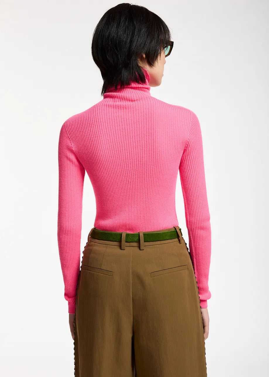 A person with short dark hair is seen from the back against a plain background, wearing the Essentiel Antwerp Kelmuse Knitted Pullover in pink paired with brown high-waisted trousers.