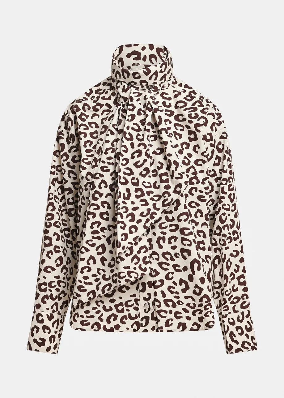 Essentiel Antwerp’s Khaleesi Leopard Print Pussy Bow Shirt in brown features an oversized long-sleeve silhouette, a bold brown and black leopard print, a high neckline, and a statement front pussy bow tie detail.