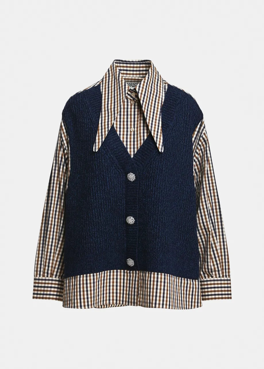 Layered beneath a navy blue textured vest with three front buttons, the Essentiel Antwerp Kute Fabric Mix Shirt features an oversized silhouette, brown and white organic cotton checks, and a pointed collar.