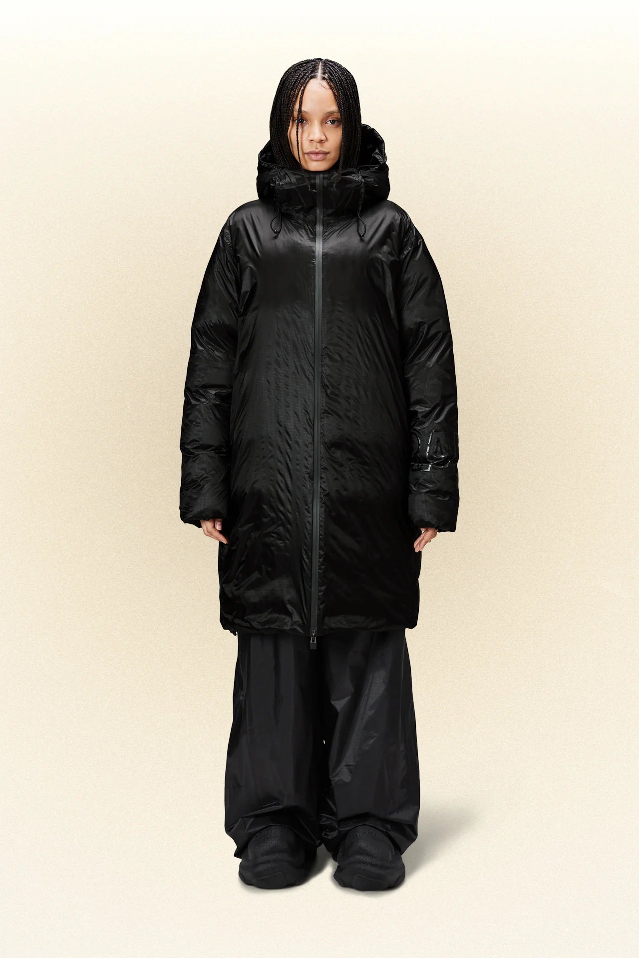 A woman wearing a Rains Kevo Long Puffer - Black coat.