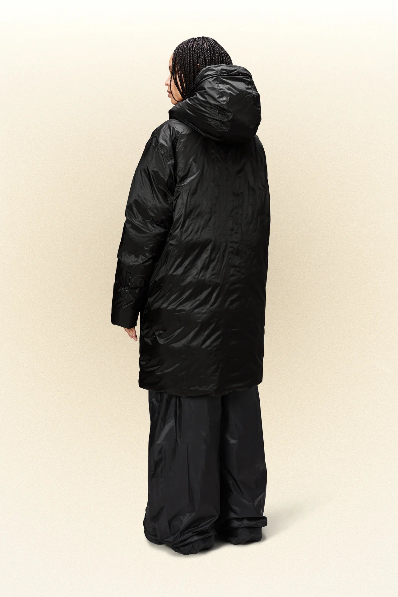 The back of a woman wearing a Rains Kevo Long Puffer - Black jacket.