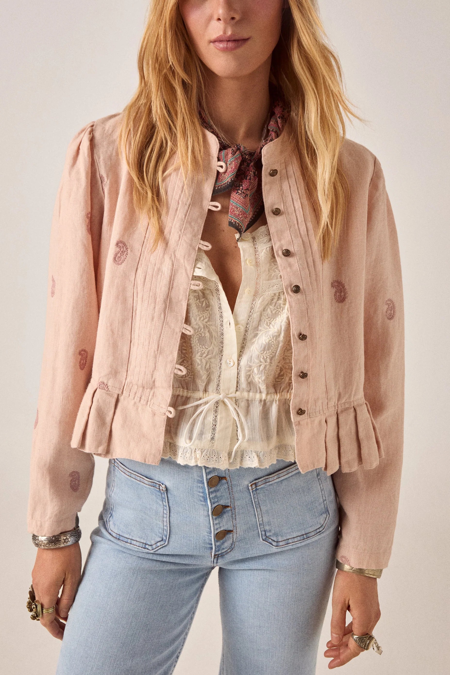 woman wears maison hotel edgar jacket in blush rose pink with light coloured jeans on a white background