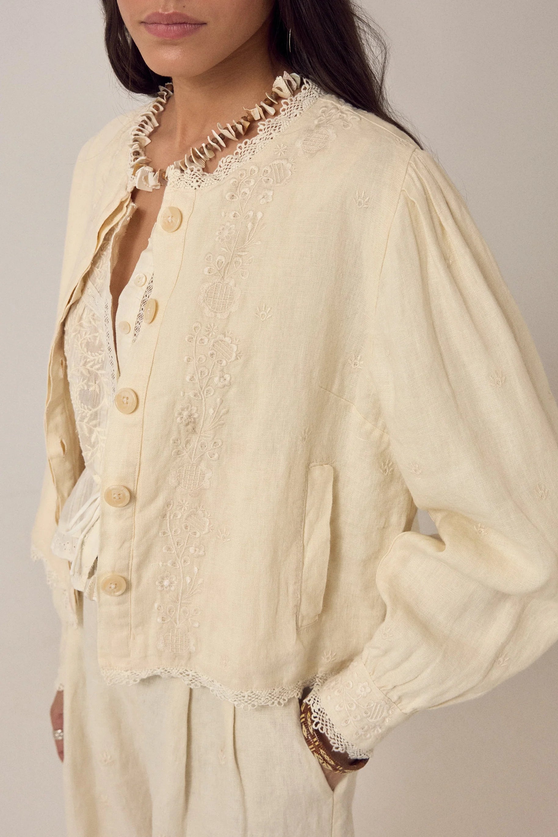 woman wears maison hotel otelo cotton and linen summer jacket in cream with linen trousers on na white background