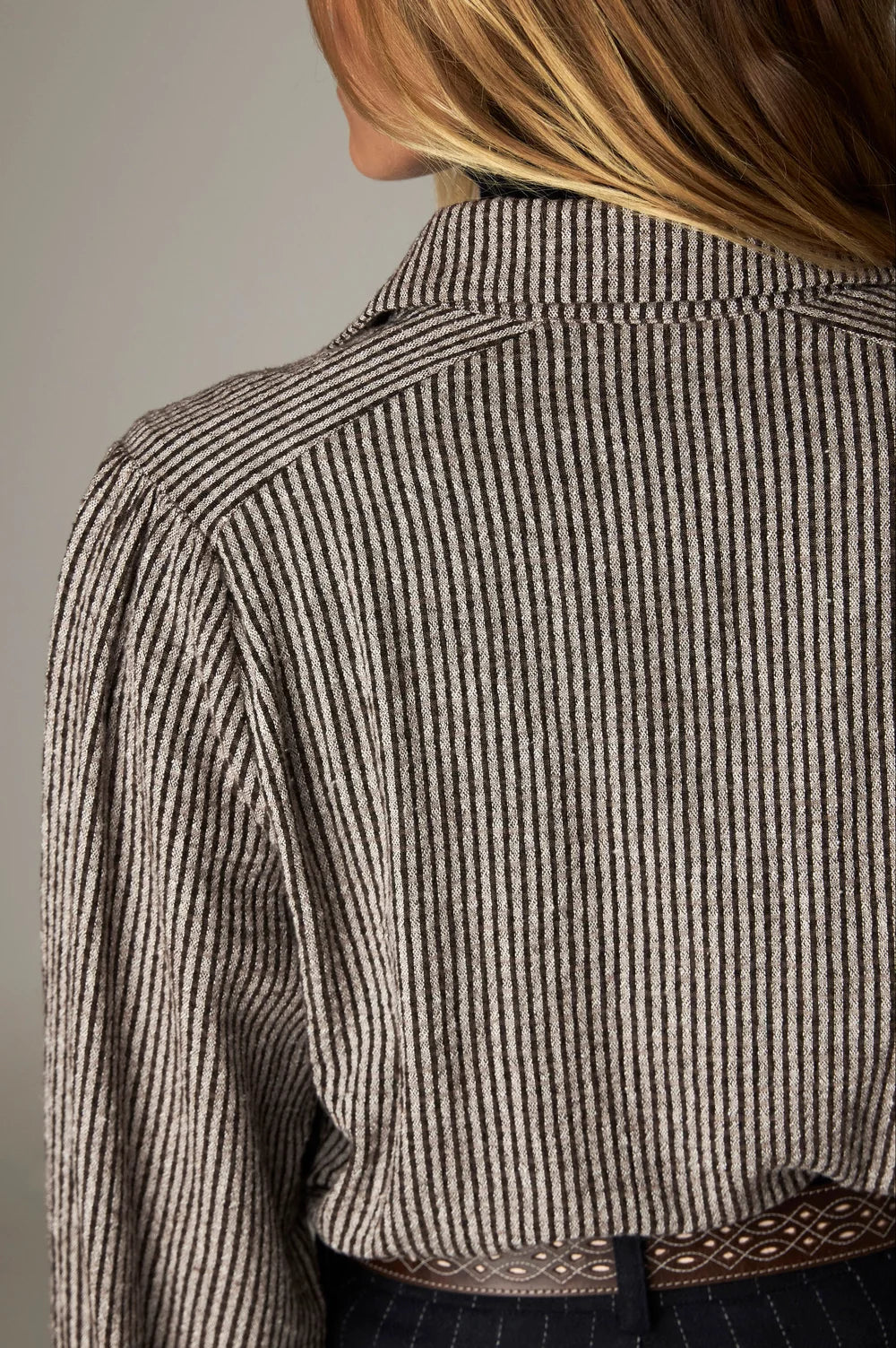 Close-up view of the back and shoulder of a Claude Blouse - Coffee Stripes bohemian blouse with a gathered yoke.
