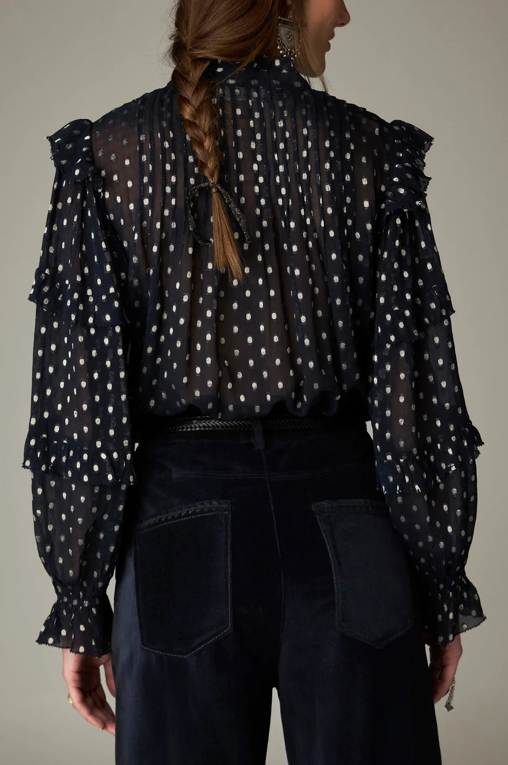 Back view of the Maison Hotel Simona Blouse - Sienna navy, a sheer metallic jacquard blouse with a high collar, ruffled shoulders, and long sleeves with gathered cuffs in a bohemian aesthetic.