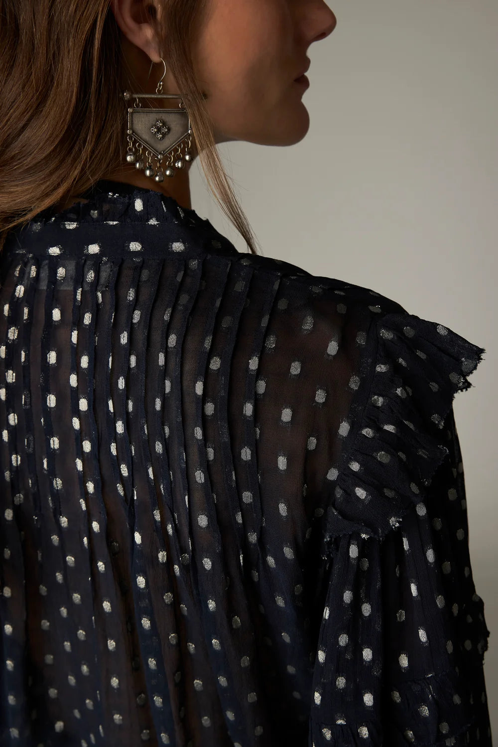 Maison Hotel Simona Blouse in Sienna navy: a dark navy metallic jacquard blouse featuring vertical pleats, silver polka dots, and bohemian-style ruffle detailing.