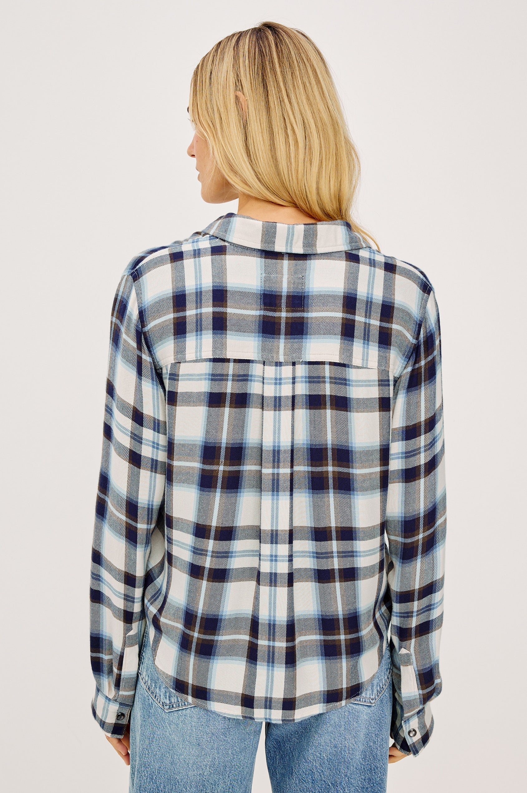Woman wearing a blue and white plaid shirt on a plain background