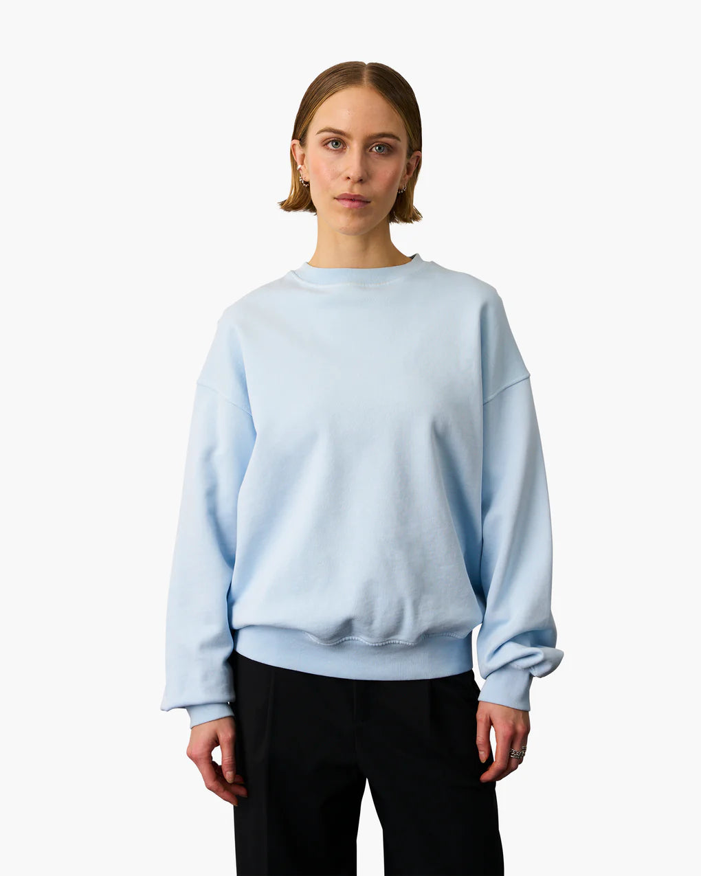 The model is wearing the Colorful Standard Organic Oversized Crew - Faded Black.