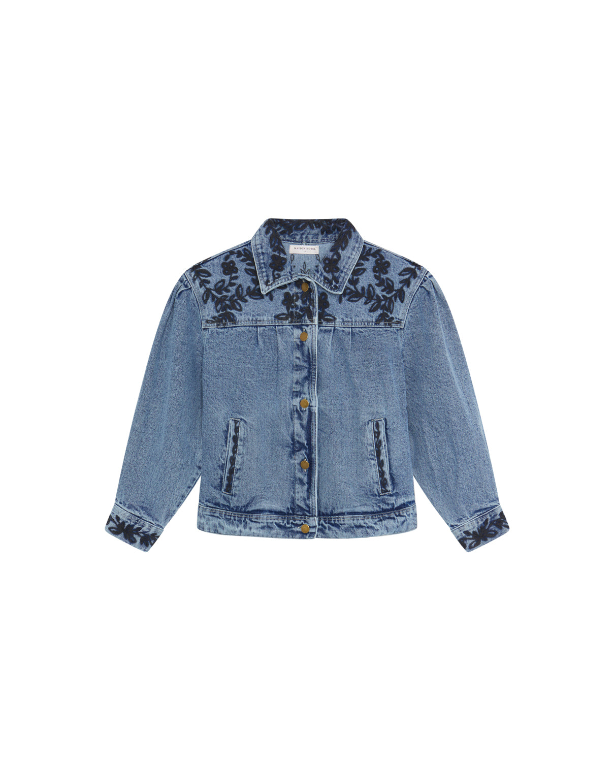 The Maison Hotel Wesley Denim Jacket in Western Blue features dark floral embroidery on the shoulders, chest, and cuffs, with front buttons and two chest pockets.