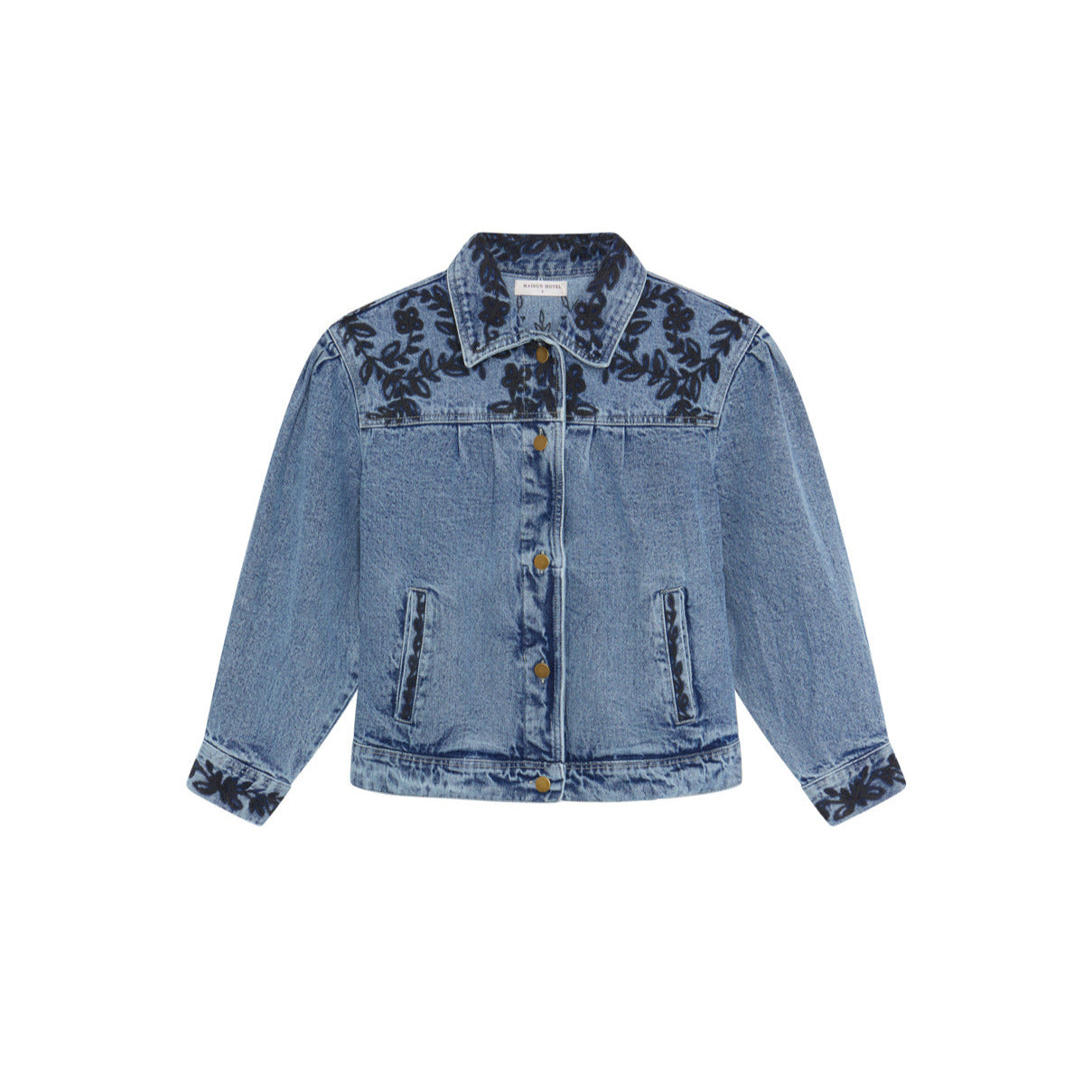 The Maison Hotel Wesley Denim Jacket in Western Blue features dark floral embroidery on the shoulders, chest, and cuffs, with front buttons and two chest pockets.