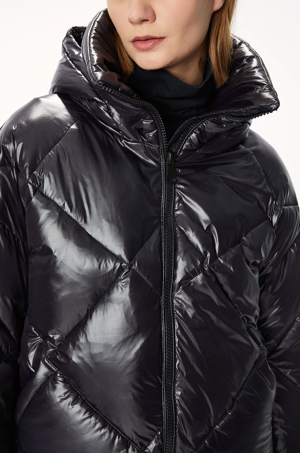 A woman donning a stylish black OOF puffer jacket 9000 with an oversized fit.