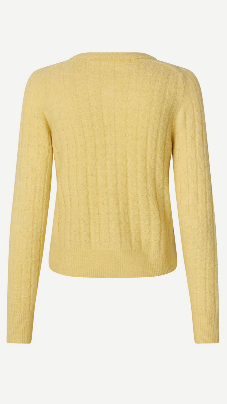 The Sabarbara Cardigan in Dusty Yellow by Samsøe Samsøe is a cozy cable-knit piece made from a wool and alpaca blend, featuring long sleeves and a round neckline, with back view details.