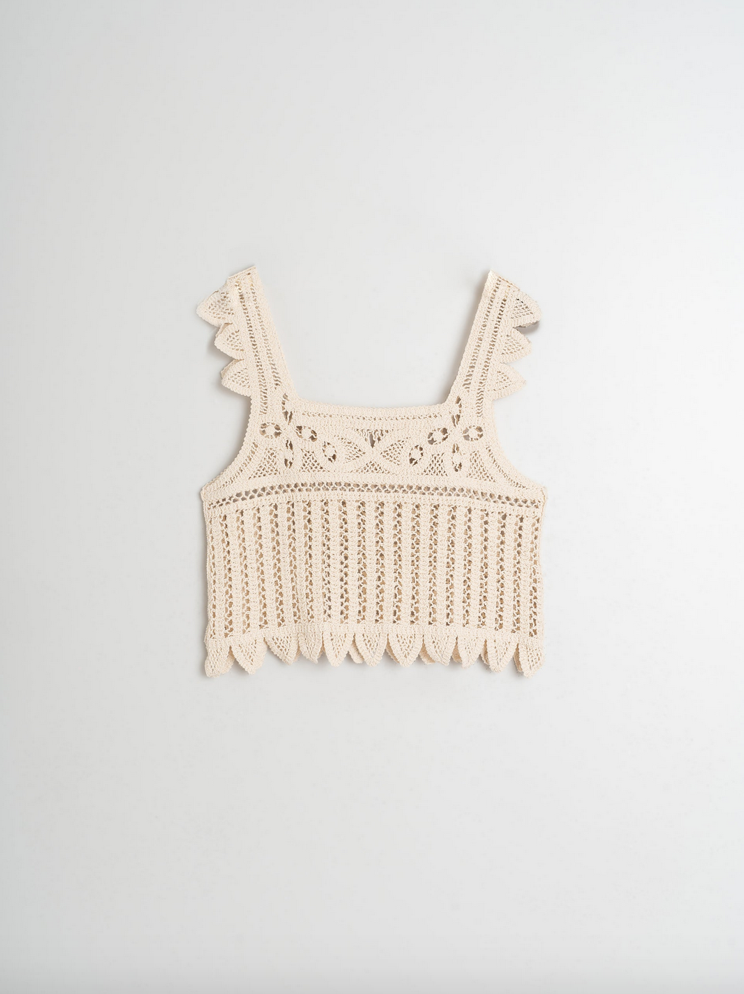 Indi & Cold's Crochet Top - Ecru is a sleeveless cotton crop top with floral motifs and scalloped edges, photographed on a plain white background.