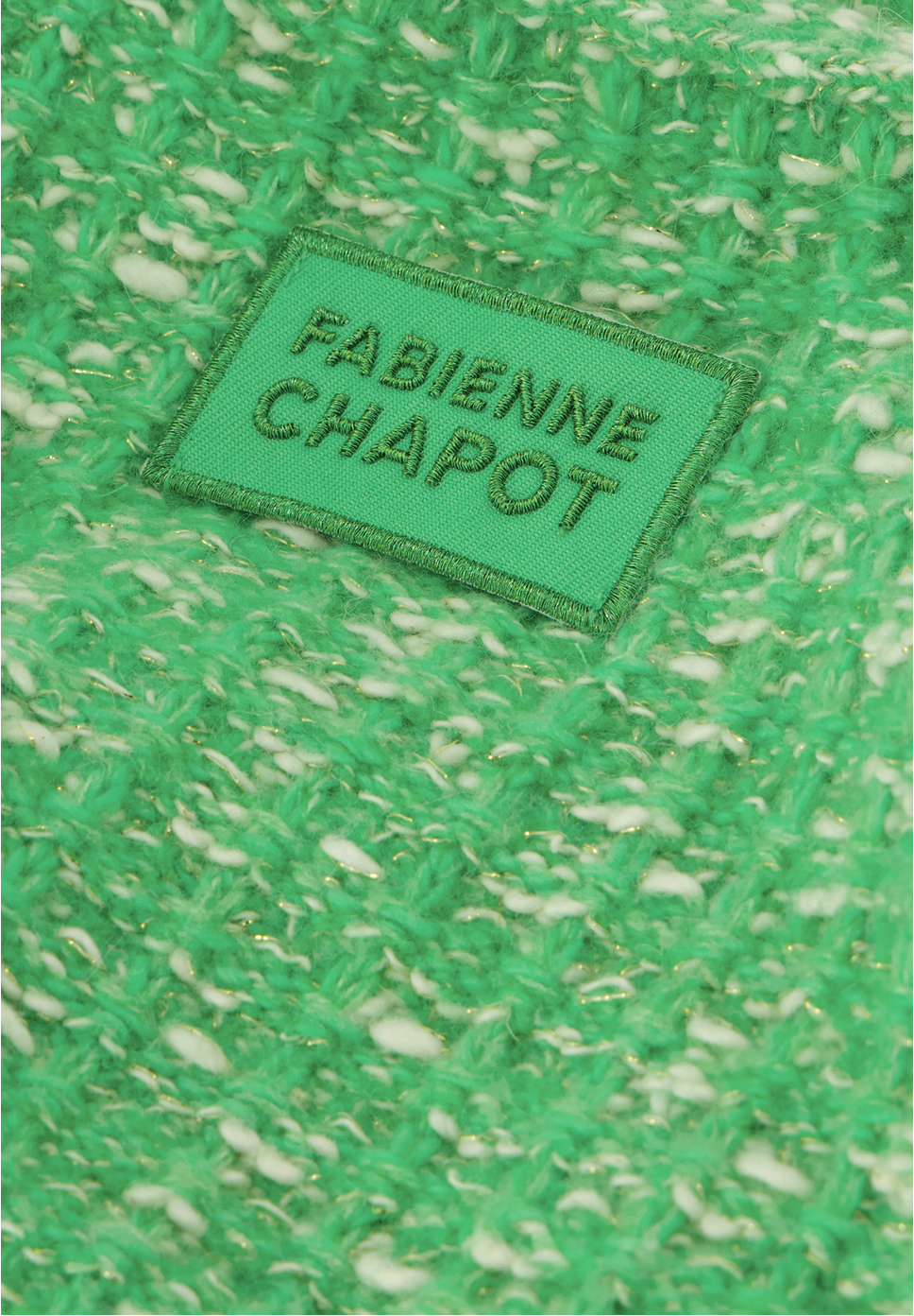 Close-up of the green and white woven fabric of the Joshua Cardigan - Green Apple, featuring a green label with "Fabienne Chapot.