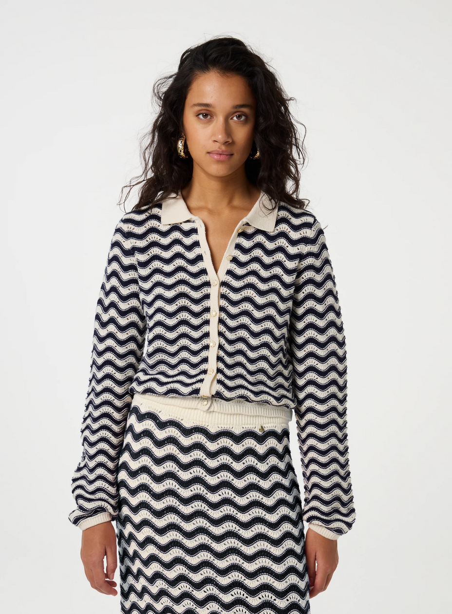 a woman wears the caro crochet cardigan by fabienne chapot in navy and off white stripes on a white background