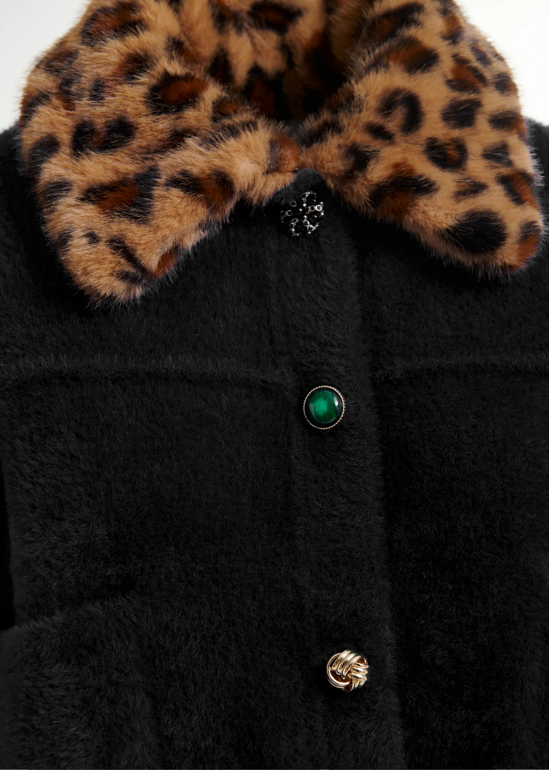 Close-up of Essentiel Antwerp's Intention Cardigan in black, featuring a removable faux fur leopard print collar and three decorative buttons in black, green, and gold tones.