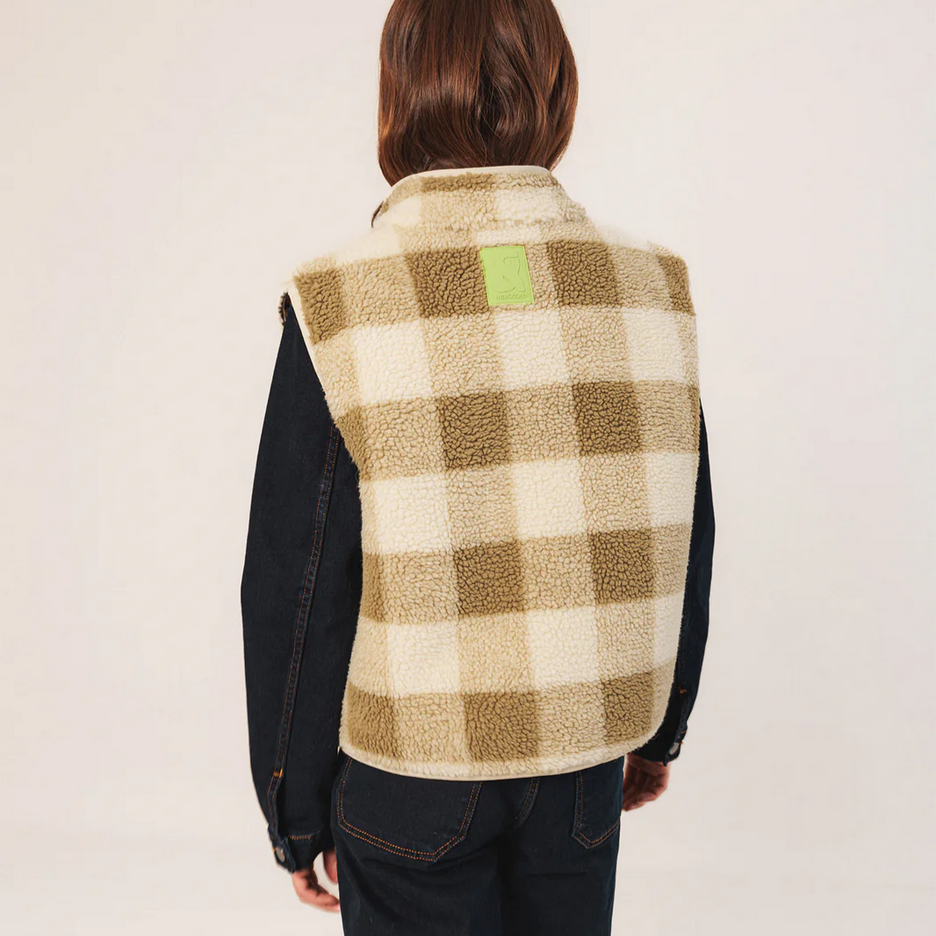 Person wearing a checkered vest with a visible brand logo on a white background