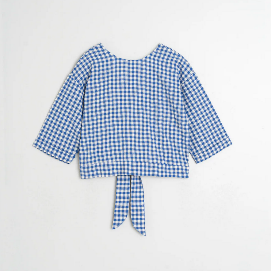 indi and cold Blue and white checkered blouse with a tie waist on a light gray background