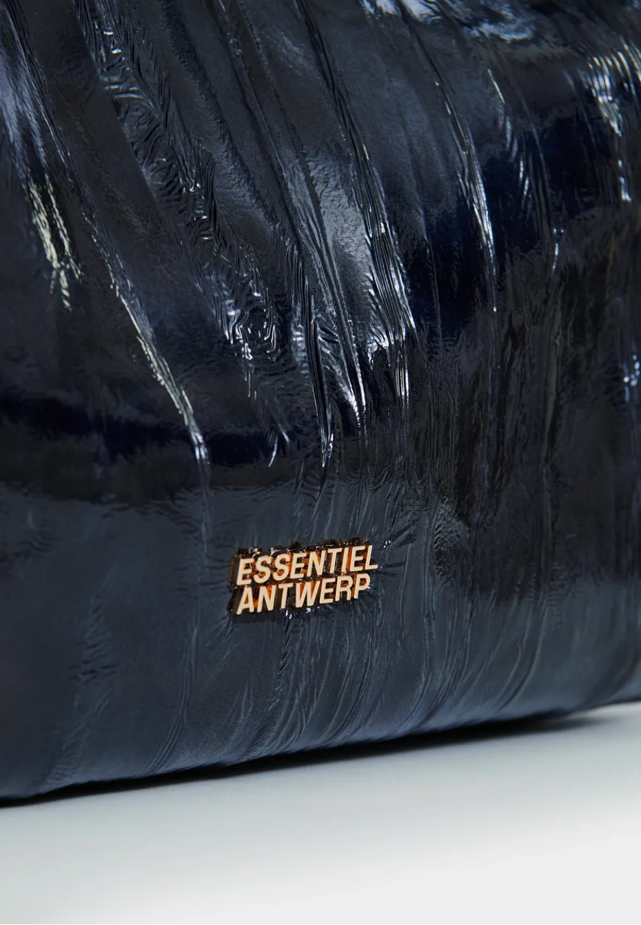 Essentiel Antwerp navy patent faux-leather JISTALO shopper handbag with a yellow strap on a white background