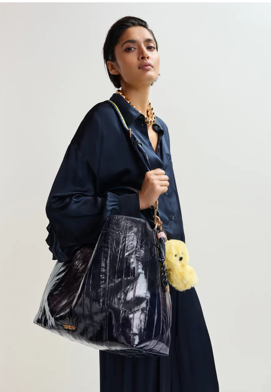 Essentiel Antwerp navy patent faux-leather JISTALO shopper handbag with a yellow strap on a white background