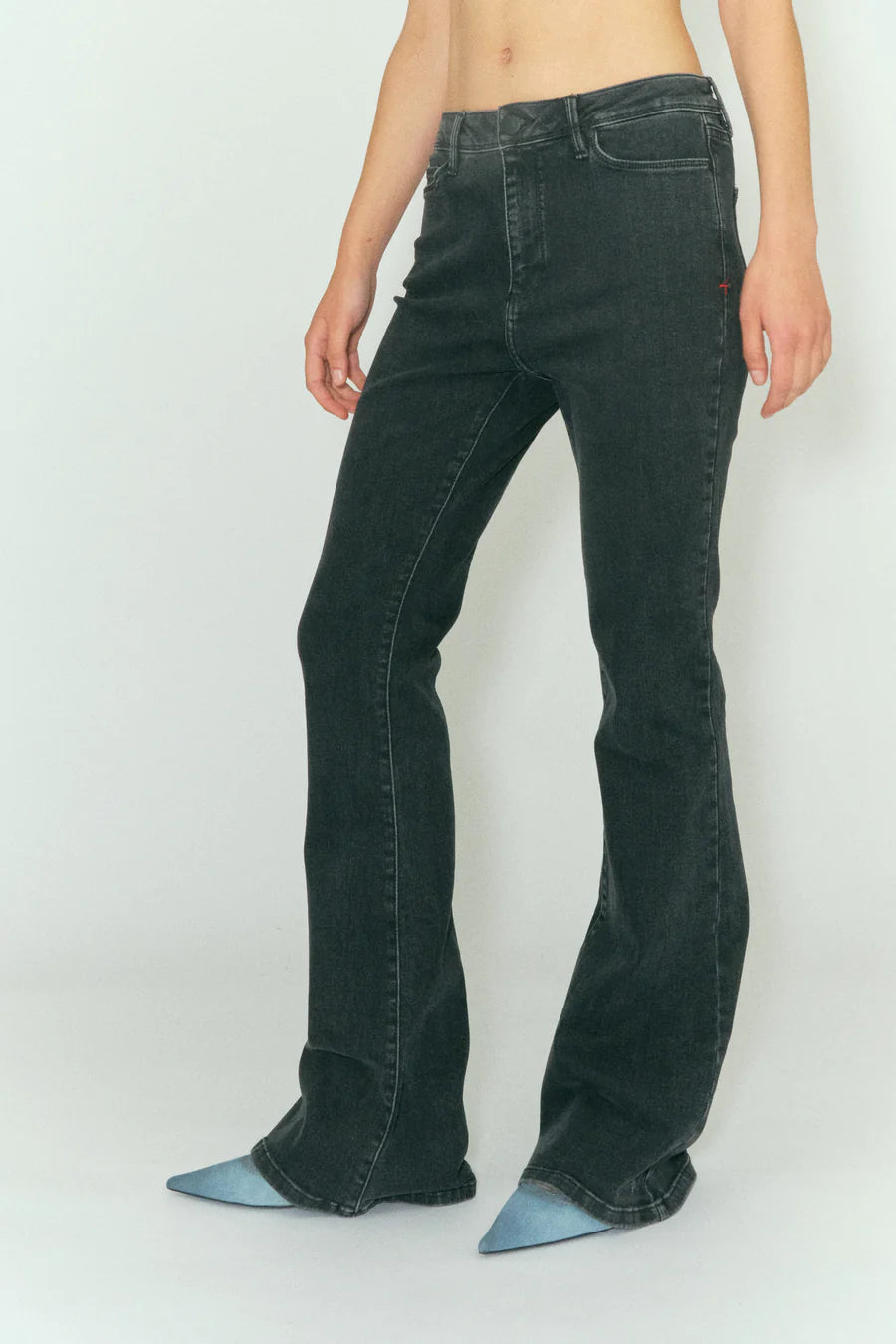 A woman is posing in a pair of Tomorrow Denim's Albert Flare - Original Black high waist black flared jeans.