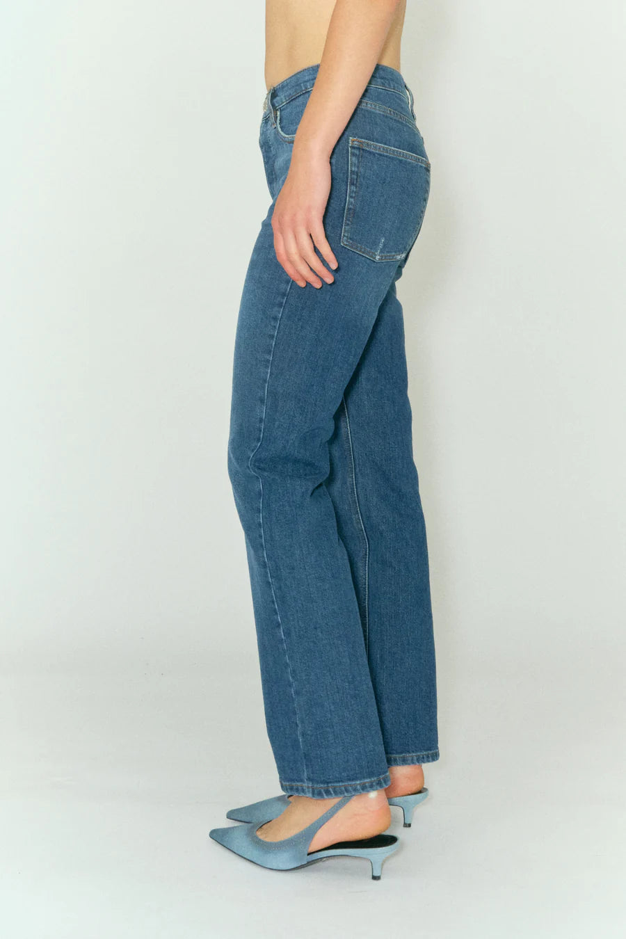 A woman in Marston Jeans - Key West by Tomorrow Denim, standing in front of a white background.