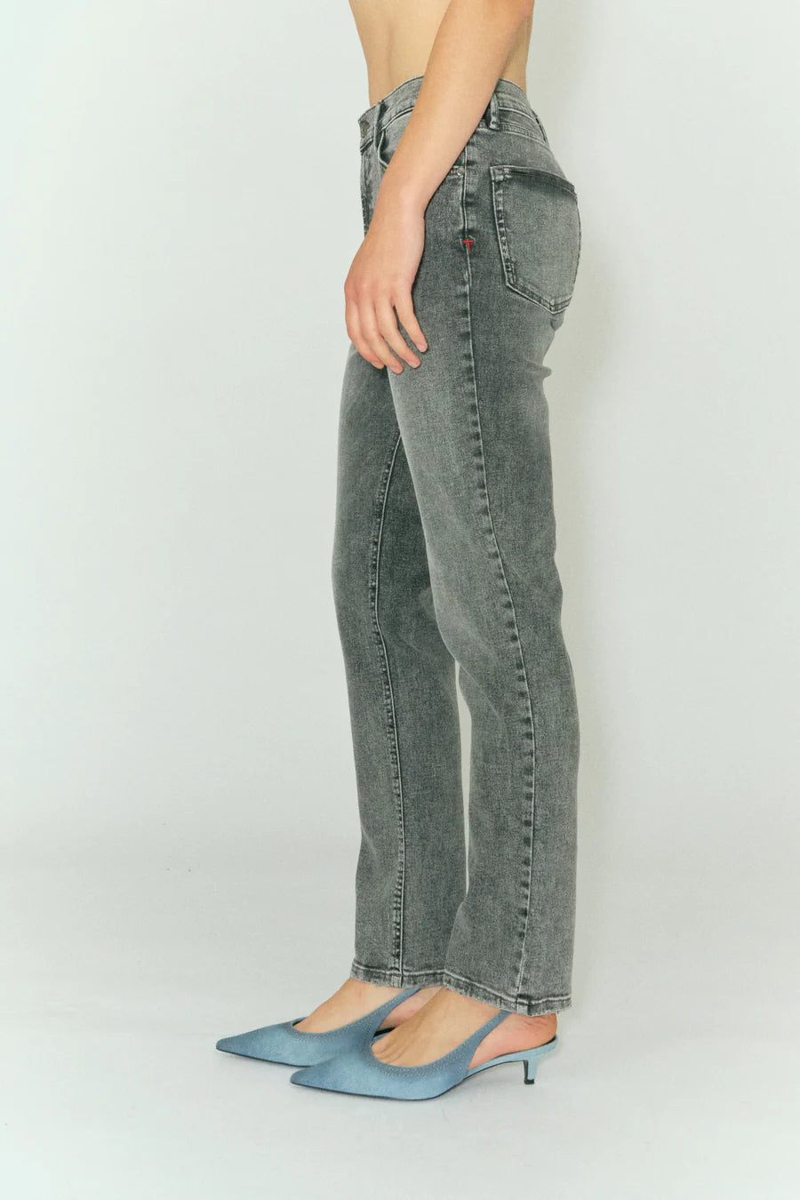 A woman wearing Tomorrow Denim's Teresa Jeans - Vintage Grey Used and blue heels.